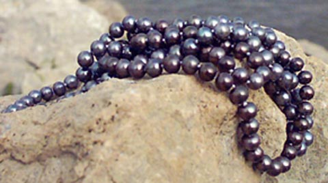 black freshwater pearls necklaces on a rock black freshwater pearls necklaces on a rock