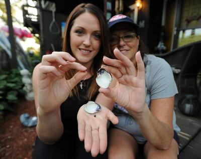 Lisa McGrath, right, and her daughter, Lindsey, discovered two pearls in a quahog while they were raking for the shellfish in Buzzards Bay.